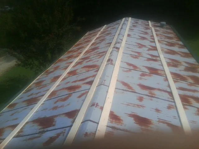 Rusted metal roof panels with new wood purlins before replacement — Storm Damage Roof Repair in Henryville by Roofing Brothers