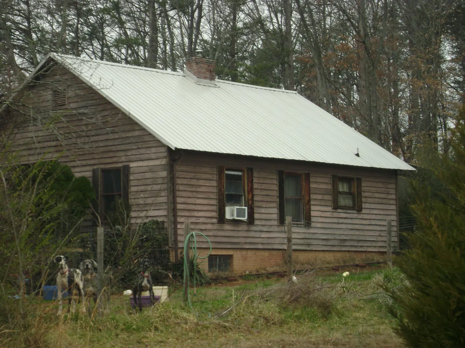 White metal roof on an old wood sided farmhouse, from a Metal Roof Installation job in Henryville